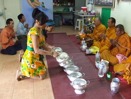 Sukanya Seaton, president of Seaton Foundation Pattaya, serves rice to monks.