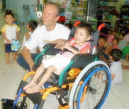 Woody visits with Fah Sai, who is in wheelchair donated by Jesters, at the Hand to Hand Foundation.