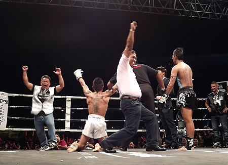 Singmanee Kaewsamrit, 2nd left, and his camp show their delight at being awarded a points decision over Sudsakorn Sor Klinmee.