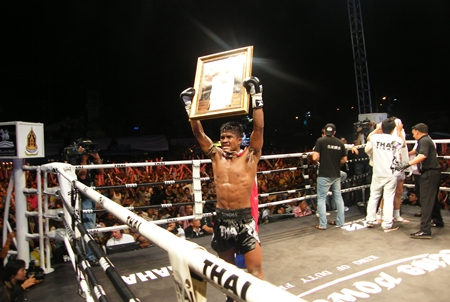 An emotional Buakaw Por. Pramuk parades a picture of His Majesty the King in the ring following his victory over Rastem.