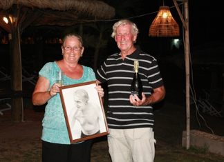 Malcolm celebrates with a bottle of bubbly while wife Norma holds the pencil sketch presented by the Royal Varuna Yacht Club to mark his amazing swim.