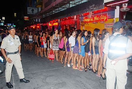 Bar workers are lined up on Soi 6 so that police can test them for drugs. 