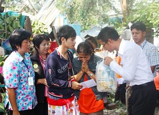 Pattaya Permanent Secretary Pakorn Sukhonthachat presents relief funds and supplies to Siriwan Kuwaentrai, grieving daughter of the deceased.