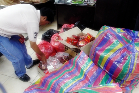 Police sort through the unlicensed, untaxed merchandise. 