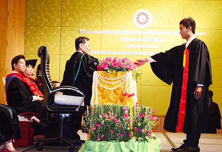 Pattaya Mail reporter Vittaya Yoondorn receives his higher vocational education certificate from Chonburi Primary Educational Service Region 3 Director Weerapong Dechbun. 