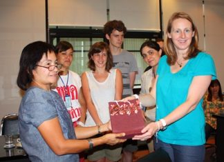 London university students study Pattaya low-income housing project Cassidy Johnson PhD (right), lecturer at the University College London presents a souvenir to Nanthanapas Khaengkhan, president of the Ban Munkhong Ban Nernrodfai, as a token of gratitude.