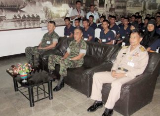 Children from Thailand’s strife-torn southern provinces sit behind navy brass during a stop in their tour.