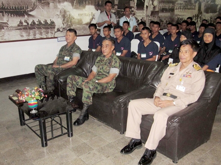 Children from Thailand’s strife-torn southern provinces sit behind navy brass during a stop in their tour. 