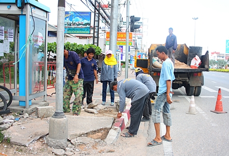 Workers repair damage caused by an accident at the Soi Siam Country Club intersection with Sukhumvit Road. 