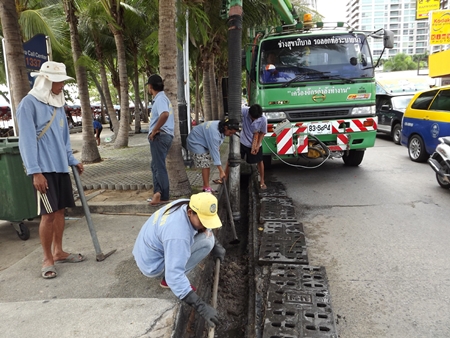 Sanitation Engineers clean dirt, garbage and sand out of the drainage pipes on Beach Road in Central Pattaya. 