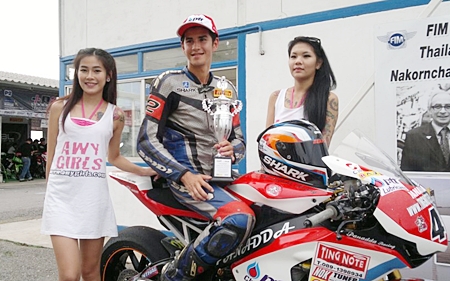 Benn Fortt, center, poses with his trophy after winning the second round of the SB2 Superbike 1000cc Thailand Championship at Nakon Chaise racetrack. 
