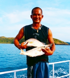 The Captain holds up two greys caught on June 2. 