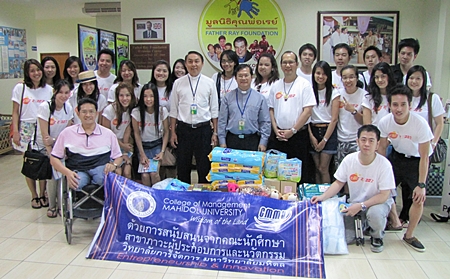 Prof. Dr. Thonapol Veerasa (centre right) along with 25 graduate students majoring in Corporate Entrepreneurship and Innovation at the Management School of Mahidol University, visit the Father Ray Foundation where they donated 10,000 baht in cash along with other amenities for use by the children. On hand to receive them were Father Pattarapong Srivorakul (centre left), president of the foundation, Father Dr. Picharn Jaiseri (centre), vice president of foundation and Suporntum Mongkolsawadi (front left), principal of the Redemptorist Vocational College for the Disabled.