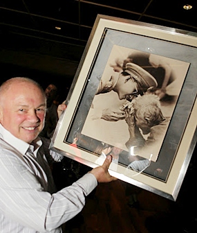 Auctioneer Peter Banner displays a wonderful framed print of his Majesty the King of Thailand. 
