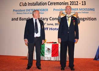 Newly elected president Dieter Reigber (right) receives his medal from the district governor (not shown), while his predecessor Gudmund Eikson looks on.