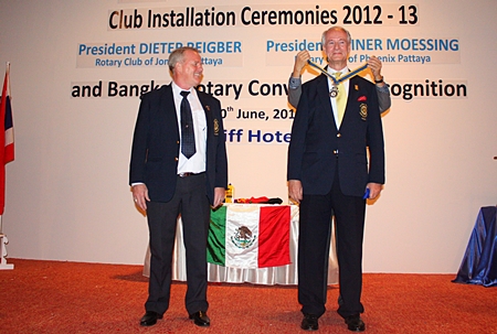 Newly elected president Dieter Reigber (right) receives his medal from the district governor (not shown), while his predecessor Gudmund Eikson looks on.