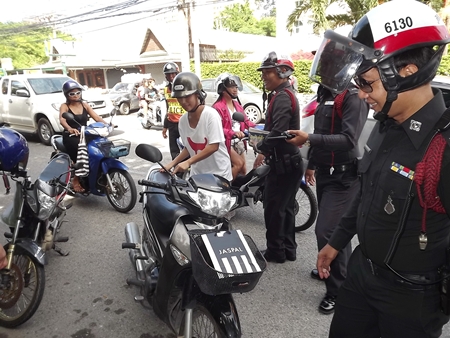Police officers search for proper driving license and vehicle registrations at a roadblock set up on Pattaya 2nd Road. 