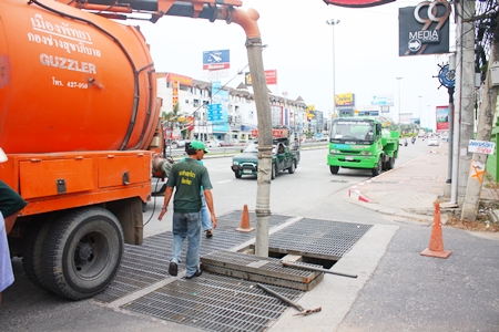 Pattaya officers use a giant vacuum pump to suck sand up out of the drainage pipes near the Father Ray Foundation. 