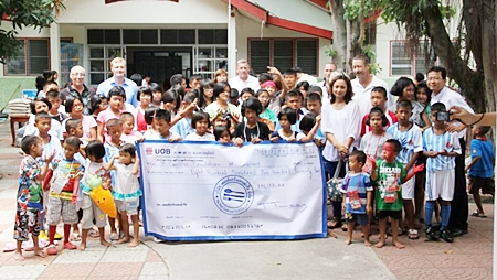 Members of the organising committee for the Camel Summer Charity Classic of 2012 present a cheque for THB 800,170 to the children and coordinators of the Camillian Social Center in Rayong. 