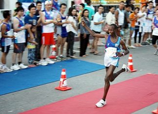 Kenyan runner Lawrence Kiptoo Saina raises his arm in victory salute as he prepares to cross the finish line on Beach Road to win the 2012 Pattaya King’s Cup Marathon, Sunday, July 15. Defending champion Kiptoo Saina completed the 42.2km course in a time of 02:22:21.