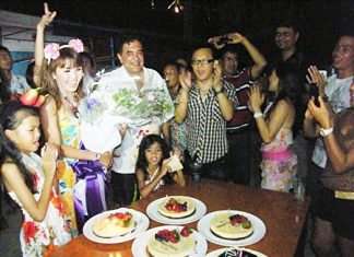 Guests gather around to sing happy birthday to Nitikorn.