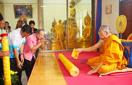 Nongprue Mayor Mai Chaiyanit (center right), and Wat Suthawat School Principal Somchok Yindeesuk (left) donate lent candles to the abbot of Wat Suthawat.