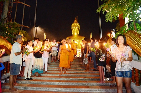 Revered monks begin the Wien Thien ceremony, carrying lighted candles three times around Wat Phra Yai.