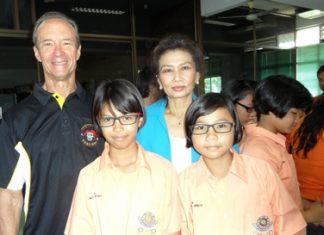 (From left) Lewis “Woody” Underwood and Nittaya Patimasongkroh with two proud schoolchildren who sport their new glasses.