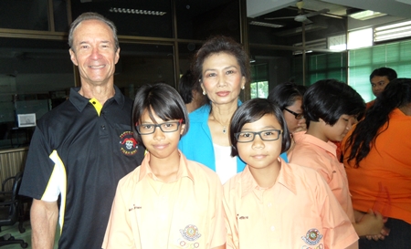 (From left) Lewis “Woody” Underwood and Nittaya Patimasongkroh with two proud schoolchildren who sport their new glasses.