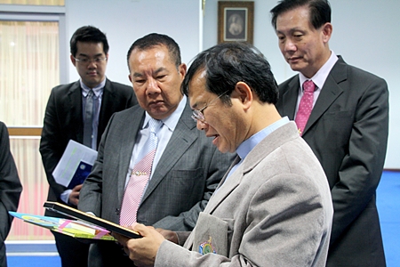 Father Michael Picharn Jaiseri (right), vice president of the Father Ray Foundation, talks with Labor Minister Padermchai Sasomsap (center), thanking him for his support for the 1479 telephone hotline.