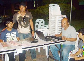 Police have arrested Saharat Phetnil (seated, left) for his involvement in a violent loan sharking ring.