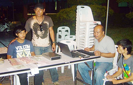 Police have arrested Saharat Phetnil (seated, left) for his involvement in a violent loan sharking ring. 