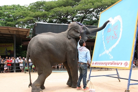 Clever 9-year-old Yok paints the words “Mother Child Love” rimmed by white jasmine flowers.