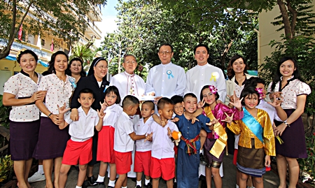 Children and care givers pose for a commemorative photo with Bishop Emeritus Thienchai Samanjit (center), along with Father Veera Phangrak and Father Kritsada Sukkaphat.