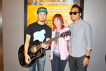 Members of the band Room 39 sign a guitar, as is tradition at the Hard Rock before a concert.