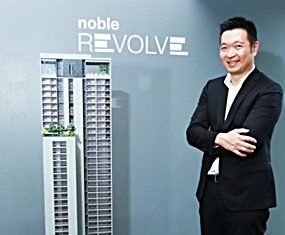 Thongchai Busrapan, Managing Director of Noble Development PCL, stands next to a scale model of the Noble Revolve project.