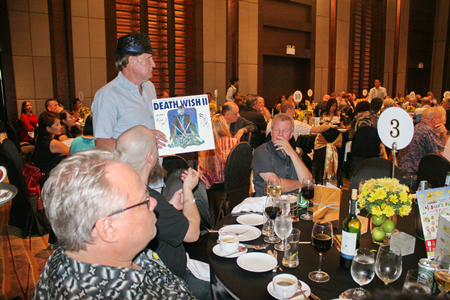 Alan from the Jesters holds up an auction item, the signed copy of Jimmy Page’s original score to the movie Death Wish.