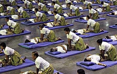 Thai masseuses perform mass massaging at a sports arena on the outskirts of Bangkok, Thursday, Aug. 30. Thailand has long been known as the massage capital of the world. Now, it has a Guinness World Record to prove it when some 641 massage therapists mass-massaged 641 people simultaneously for 12 minutes to win the honor Thursday. The event was organized by the Health Ministry to promote the Southeast Asian nation’s massage and spa industry. (AP Photo/Apichart Weerawong)