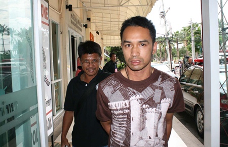 Police bring in Rangsiman Saengworanut for his alleged involvement in an ATM card theft. 