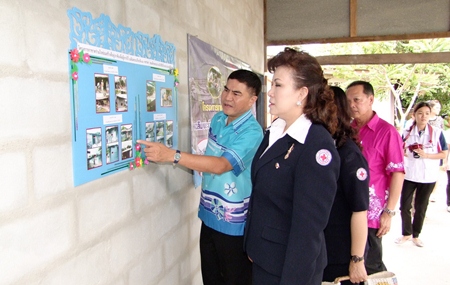 Red Cross President Bussarawadee Ekachai is shown plans to refurbish or build houses for poor people in Banbung and Panthong districts. 