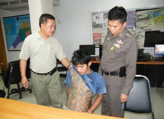 Police inspect the tattoos on suspected snatch thief Ekalak Chaemchoi.
