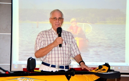 Master of Ceremonies Richard Silverberg admires the fully assembled inflated kayak at the PCEC meeting.