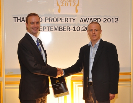 Kingdom Property Head of Sales and Marketing Henri Young, right, and Ensign Media and Thailand Property Awards CEO Terry Blackburn, left, shake hands on the new sponsorship agreement.