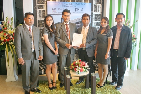 Chitsanucha Phakdeesaneha, center right, GM of the Porchland Group, accepts the 55 million baht loan agreement from LH Bank area manager Somchai Leangraksa, center left, at a signing ceremony held Sept. 25. Also in the photo are Thorberm Prajuabsuk, senior lending officer of LH Bank, Pattaya Klang Branch; Pamikhada Philakeaw, sales executive Porchland Group; Paradee Ticomrum, secretary & marketing Porchland Group; and Thanapisit Chuabanlue, manager of Vorakit Construction. 