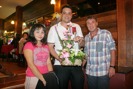 (L to R) Allan Ottesen (centre) who now runs the business for his mom and dad receives a bouquet  from well-wishers.