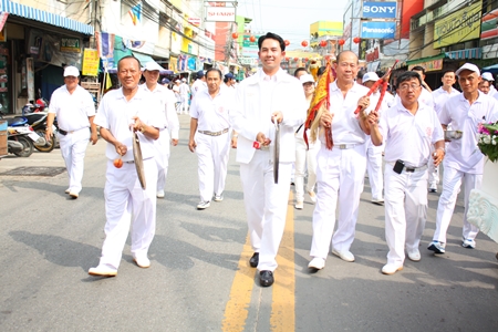 Prasit Thongthitcharoen (left), vice president of the Sawang Boriboon Thammasathan Foundation, and Mayor Itthiphol Kunplome sound their gongs whilst leading the lions and dragon parade through New Naklua market.