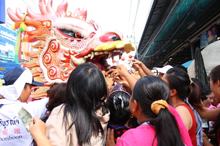 People scramble to feed the dragon and make merit.