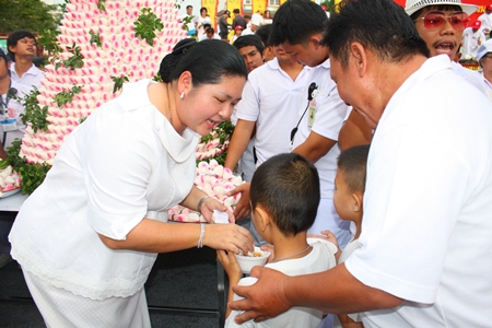 Culture Minister Sukumol Kunplome distributes heavenly peaches to youngsters and others during the festival at the Sawang Boriboon Thammasathan Foundation in Naklua.
