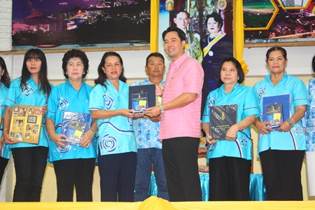 Naowarat Khakhay (3rd left), and members of the Women’s Development Group present Thai encyclopedias to Mayor Itthiphol Kunplome, representing the school. 