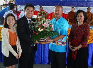 Suwat Rotchatwattanakul (2nd left), vice president of Nongprue PAO, presents flowers congratulating Suwat Nongyai, school licensee, with Waraporn Jandech, director of Pattaya Arunothai School, on the school’s 40th Anniversary.